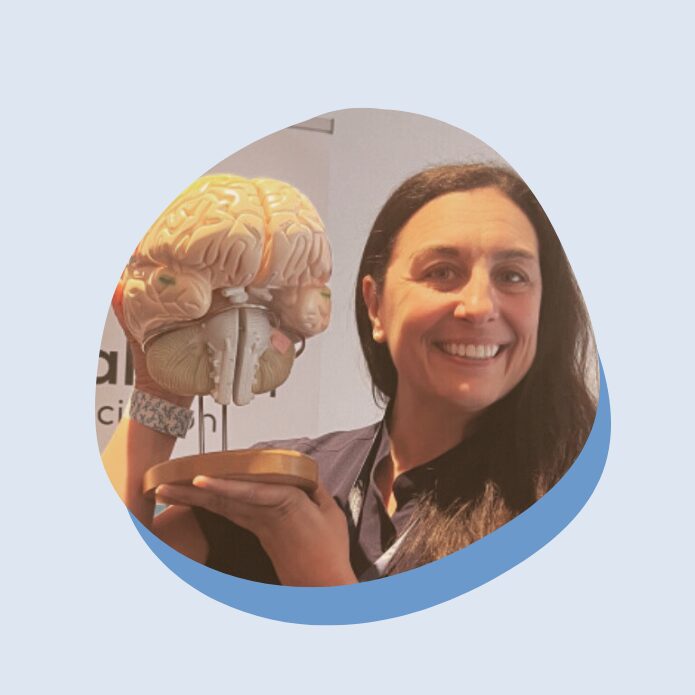 “That’s When I Realized: I Have Migraine.” Beth’s Empowerment Story A woman smiles while holding a model of the brain